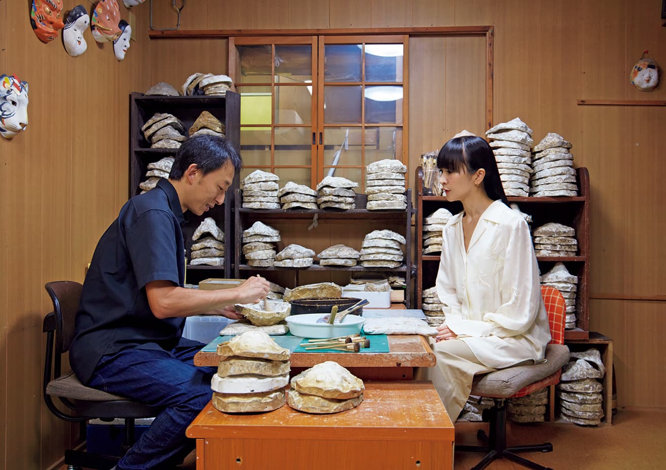 嵯峨面は、京都の嵯峨で作られる張り子の面。その作者・三代目藤原孚石さんは、藤原裕之の名で活動する日本画家でもある。石膏型に和紙を貼り重ねる様子を見て「時代を経た紙の味わいを生かすんですね」とかしゆか店主。